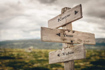 know your value text quote on wooden directional signpost outdoors in nature