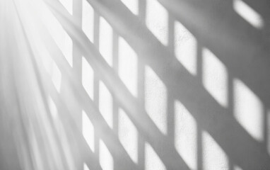 Sunlight streaming through a window casting shadow patterns on a white wall. Minimalist abstract image with geometric light and shadow interplay.