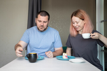 Family dinner, husband and wife drinking coffee and eating cake at home, enjoying a peaceful meal together, indulging in sweet treats and coffee, relaxing in their dining room.