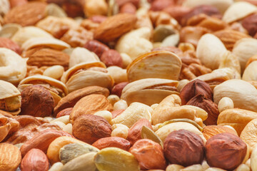 Variety of nuts and seeds closeup with selective focus - peeled walnut, hazelnuts, peeled peanut, pine nut kernels, almond seeds, cashew seeds, pistachio nuts in the shell, pumpkin seeds