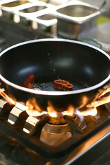 Chef grilling peppers in a pan in a hotel kitchen