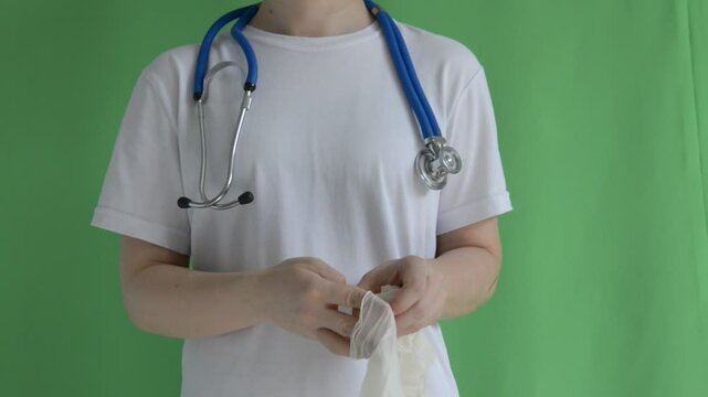 A doctor without a face wears gloves on a green background, monochrome