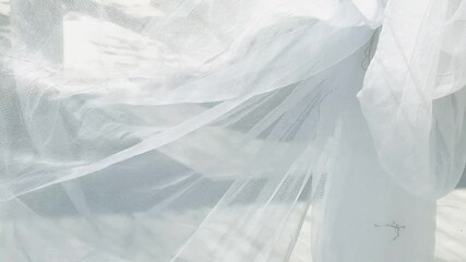Transparent white curtain fabric moves in the breeze.