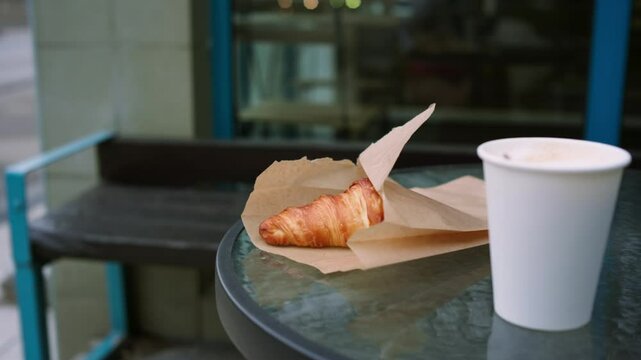Taking coffee with croissant in cafe