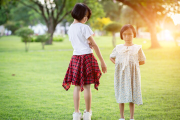 Two young girls are hugging each other in a park