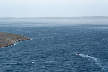 Obraz premium Boat sails on wavy sea on wind
