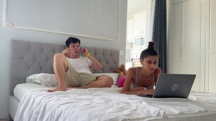 Teenagers Enjoying a Relaxing Time Together While Happily Using a Laptop on Their Bed - Powered by Adobe