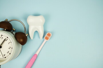 Toothbrush and Tooth with alarm clock dental hygiene concept top view on blue background