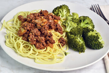 spaghetti  servedwith mushroom meat sauce with broccoli