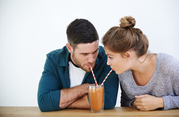 Love, milkshake and cafe with couple on date for romance, bonding and happiness. Smoothie, coffee shop and care with man and woman sharing drink at restaurant for summer, break and relationship