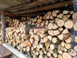 A pile of wood stacked on top of each other in a shed