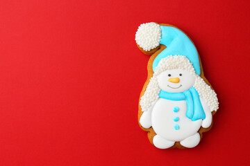Tasty Christmas cookie in shape of snowman on red background, top view. Space for text