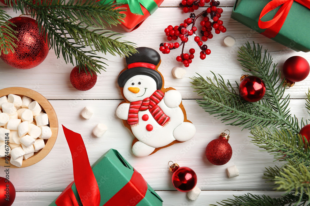 Wall mural Delicious cookie in shape of snowman, marshmallows and Christmas decor on white wooden table, flat lay