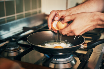 Home, hands and chef with eggs for cooking, frying and morning breakfast in apartment kitchen. Culinary, male person and cook with protein food by stove, vitamin A diet and healthy nutrition in pan