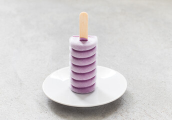 Modern Vegan Black Grape ice cream in the shape of a spiral. On a plate. Close-up