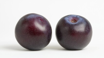 Fototapeta premium Two ripe plums on a white background, showcasing their smooth, shiny skin.