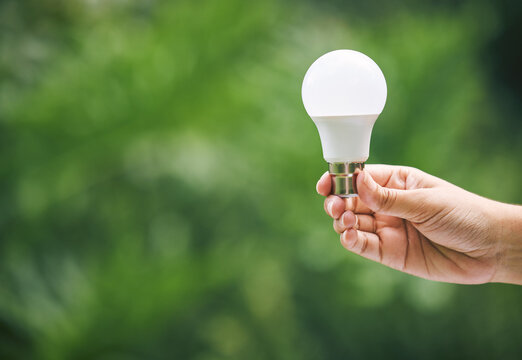 Hands, nature and light bulb for eco friendly, sustainability and idea with renewable energy innovation. Person, lamp and solar power for electricity, inspiration and mockup space with solution