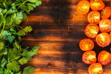 Cherry tomatoes and cilantro on a wooden board. Copyspace.