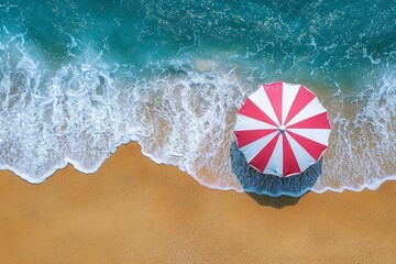 Obraz premium Red and White Striped Beach Umbrella on Sandy Shore with Foamy Waves