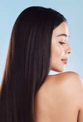 Fototapeta premium Girl, thinking and hair care in studio for cosmetics in profile, back or healthy by blue background. Model, woman and person with hairstyle, change or transformation with beauty, results or wellness