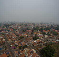 Obraz premium An aerial photo of the city of Campo Grande - MS, Brazil, with a gray sky, with a lot of smoke due to fires in times of drought throughout the country. Photo taken on September 14, 2024.