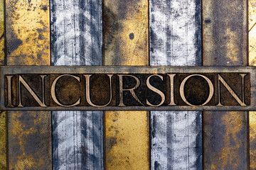 Incursion text in real authentic typeset letters on vintage textured silver grunge copper and gold background