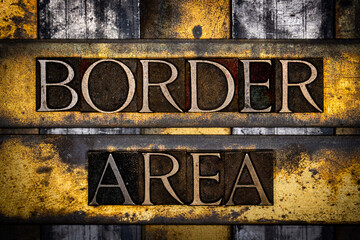 Border Area text in real authentic typeset letters on vintage textured silver grunge copper and gold background