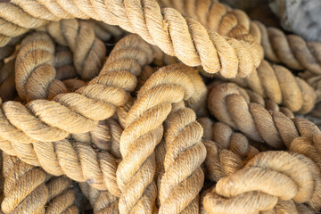 Rope texture. Close-up of a coil of rope. A beige or brown rope lies in the sun.