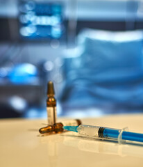 a syringe with a vaccine lies on a table in a hospital ward