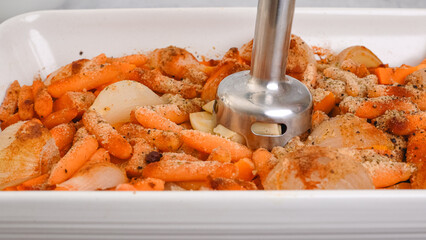 Roasted butternut squash soup recipe, preparation process. Roasted vegetables in a ceramic baking dish, close-up