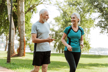 Senior couple wearing sportswear walking and talking in the park