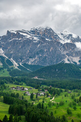 A panoramic view of the picturesque town of Cortina d'Ampezzo, nestled in the heart of the Dolomites. Majestic mountains rise in the background, offering a stunning natural backdrop.