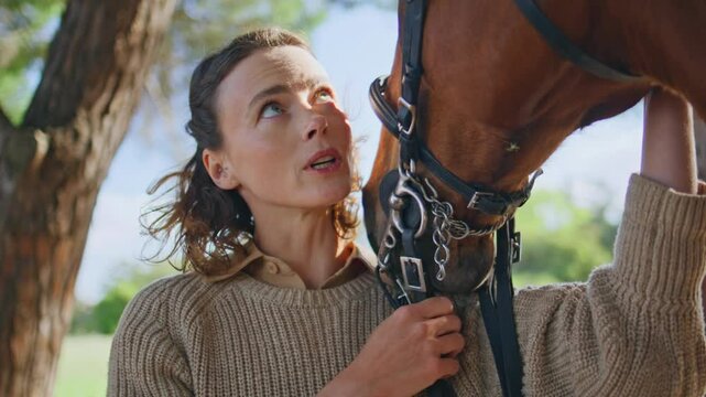 Lady stroking healthy horse in beautiful nature closeup. Woman touching muzzle
