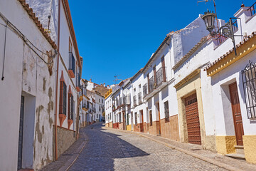 Narrow street, buildings and ancient architecture for village travel, history tourism and vintage location. Urban, neighborhood and city with traditional culture, holiday sky and destination in Spain