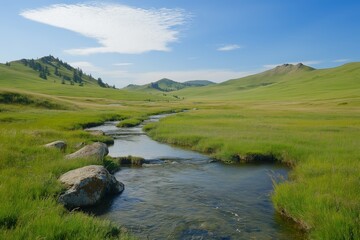 Obraz premium A river runs through a grassy field with a clear blue sky above. The scene is peaceful and serene, with the water reflecting the sky and the surrounding landscape