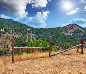 Fototapeta premium Nature, landscape and fence on mountain in Spain for environment, travel and scenic destination. Natural background, wallpaper and hills, sky and wooden posts in countryside, outdoors and terrain