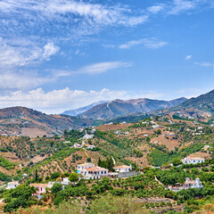 Fototapeta premium Blue sky, buildings and town for travel, destination or holiday in Andalusia with vintage architecture. Location, nature and ancient houses outdoor in village for vacation, getaway or trip in Spain.