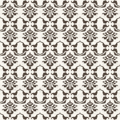 A decorative pattern featuring intricate floral motifs in brown and cream.