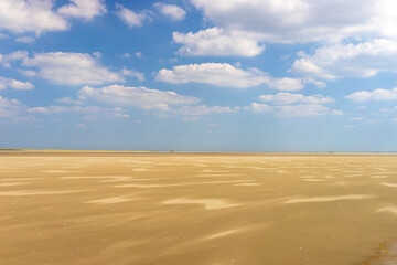 Wide panoramic view of  a beach on a sunny bright day in the Baie de Somme natural reserve in northern France by the English channel