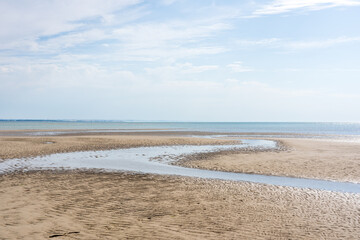 Wide panoramic view of  a beach on a sunny bright day in the Baie de Somme natural reserve in northern France by the English channel
