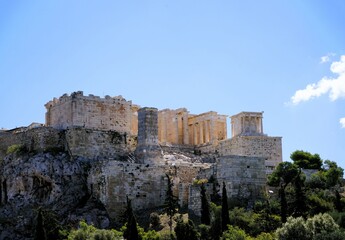 Panoramic view over the Acropolis and the temple of the Parthenon with a tall green cypress tree in the foreground in Athens, Greece, Europe.
