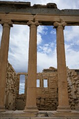 Obraz premium Columns and marble remains of the mighty Parthenon on the hill of the Acropolis in Athens, sacred temples of the goddess Athena and tutelary goddess of the city - sightseeing and vacation in Greece