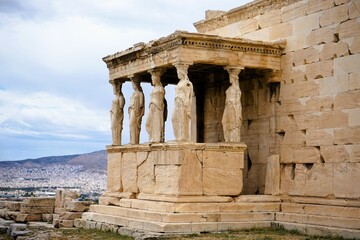 Obraz premium Athens, Greece, 08.26.2024: Famous marble statutes on The Porch of the Caryatids in the Erechtheum on the hill of the Acropolis of Athens in Greece, Sightseeing and vacation in Griechenland