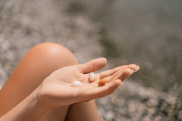 A person is holding a handful of nuts in their hand. The nuts are of different sizes and shapes, and they appear to be almonds. The person seems to be enjoying the nuts and is likely to eat them soon.