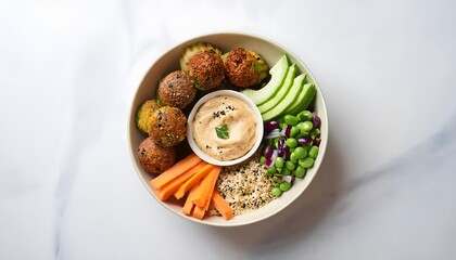 A Mediterranean-inspired Buddha bowl featuring falafel, hummus, quinoa, fresh veggies, and tahini sauce, beautifully presented on a white background.