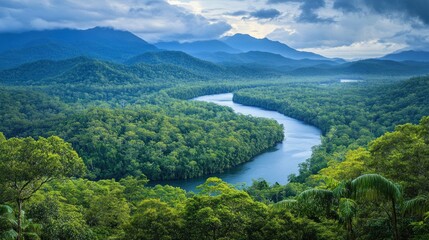 A winding river snakes through a lush green valley, surrounded by towering mountains and a dramatic sky.