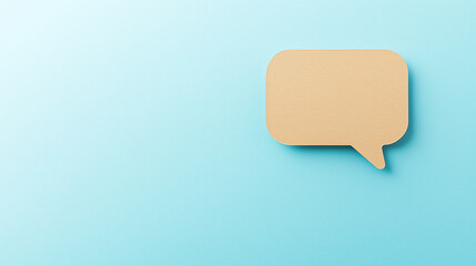 Naklejka premium Photo of a speech bubble cut out from light brown cardstock, placed on a light blue background. Craft speech bubble design.