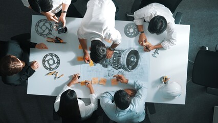 Top down aerial view of smart engineer team working together to design turbine engine. Professional...