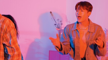 Close up of break dancer team dancing together at modern studio with pink led light. Multicultural people moving to hip hop music while wearing stylish fashion cloth. Crazy, funny mood. Regalement.