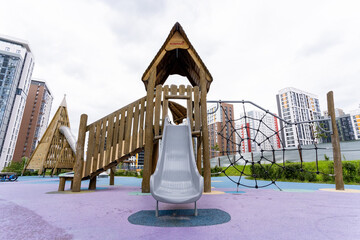 A contemporary playground structure complete with a slide and various climbing features beautifully...